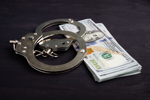 Handcuffs and money. Dollars for bail bonds.
